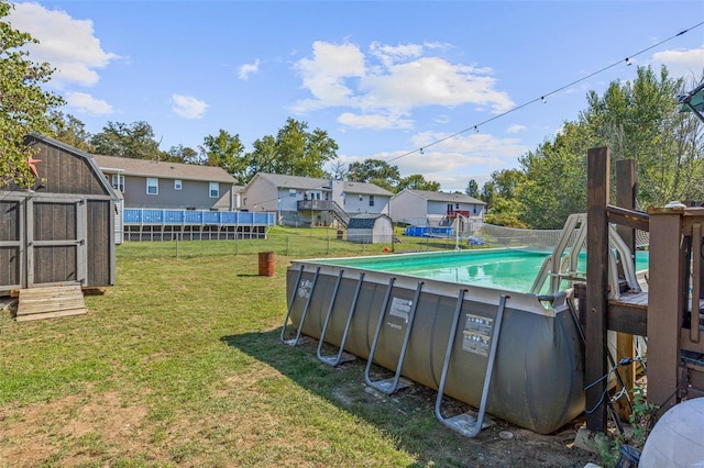 view of pool with a lawn and a shed