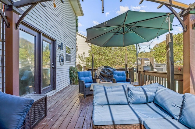 wooden deck with an outdoor living space and area for grilling