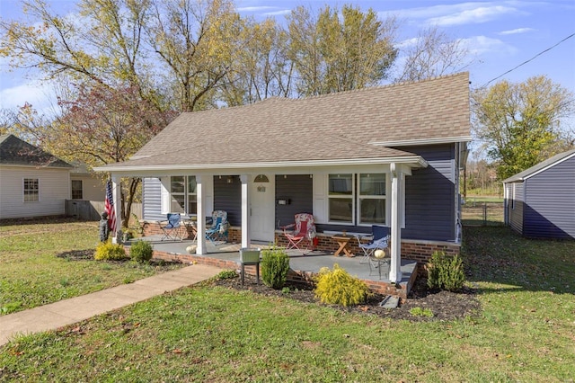 bungalow-style home featuring covered porch and a front yard