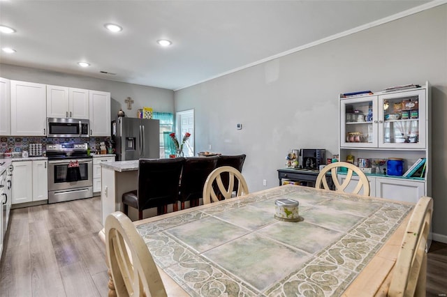 dining room featuring crown molding and light wood-type flooring