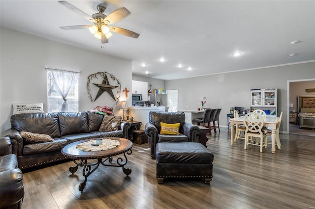 living room featuring ceiling fan, dark hardwood / wood-style floors, and ornamental molding