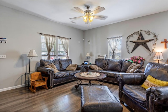 living room featuring ceiling fan and dark wood-type flooring