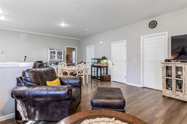 living room featuring dark hardwood / wood-style flooring and ornamental molding