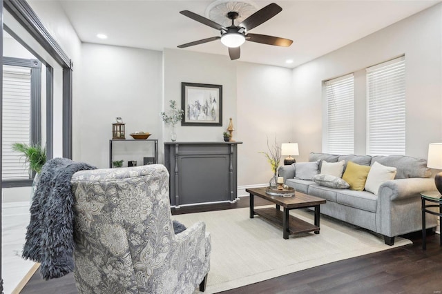 living room featuring dark wood-type flooring and ceiling fan