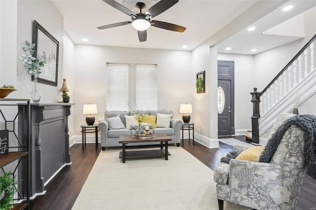 living room featuring ceiling fan and dark hardwood / wood-style floors