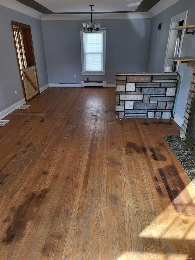 unfurnished dining area with an inviting chandelier, wood-type flooring, a fireplace, and a baseboard radiator