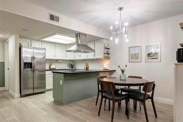 kitchen with white cabinets, kitchen peninsula, stainless steel fridge with ice dispenser, ventilation hood, and light hardwood / wood-style floors