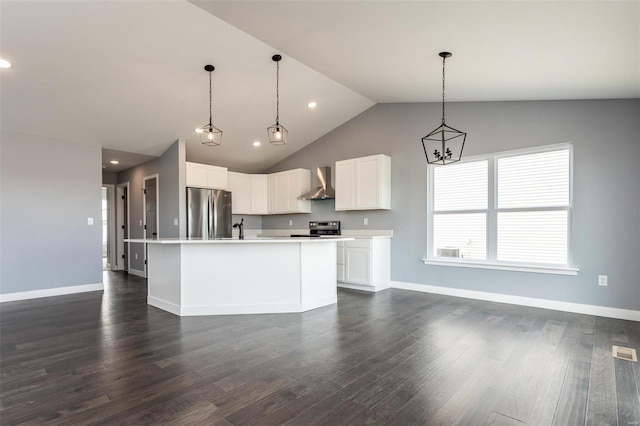 kitchen featuring white cabinetry, dark wood-type flooring, stainless steel appliances, wall chimney range hood, and an island with sink