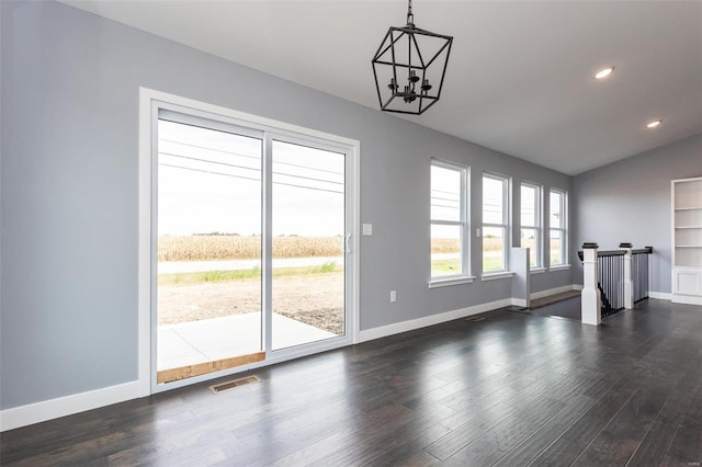 interior space featuring a chandelier, vaulted ceiling, and dark wood-type flooring