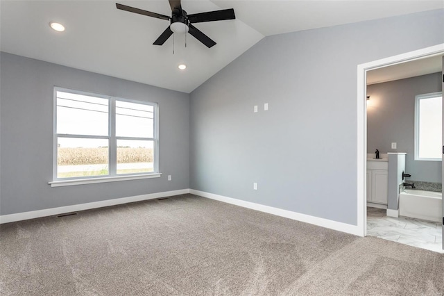 empty room with light carpet, vaulted ceiling, and ceiling fan