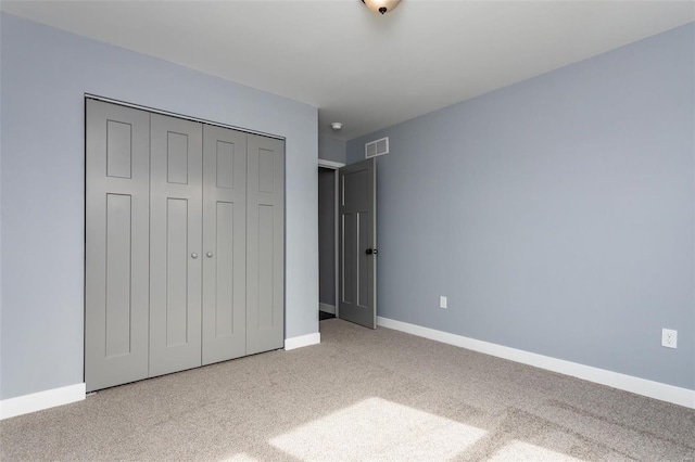 unfurnished bedroom featuring carpet flooring and a closet