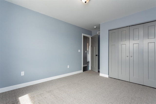 unfurnished bedroom featuring light colored carpet and a closet