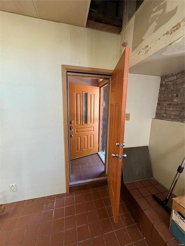 hall featuring dark tile patterned flooring