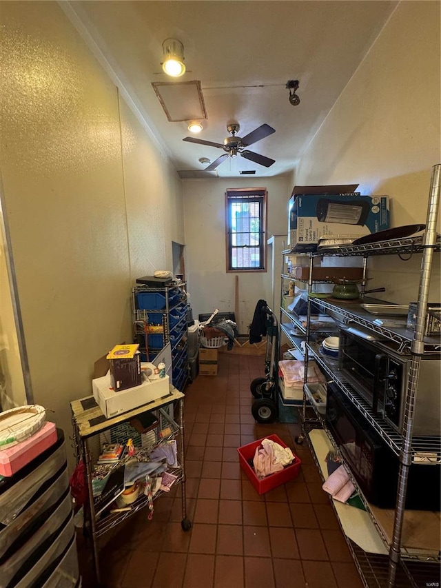 misc room with crown molding, ceiling fan, and dark tile patterned flooring