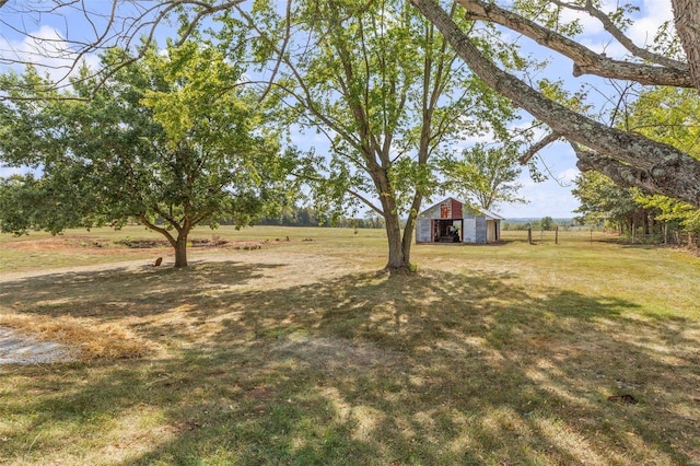 view of yard featuring a rural view and an outbuilding