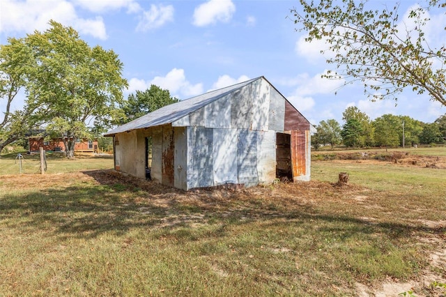 view of outbuilding with a lawn and a rural view