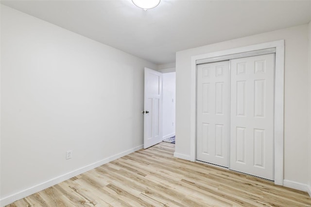 unfurnished bedroom featuring light wood-type flooring and a closet