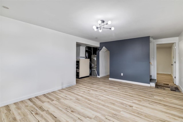 spare room featuring light hardwood / wood-style flooring and a notable chandelier