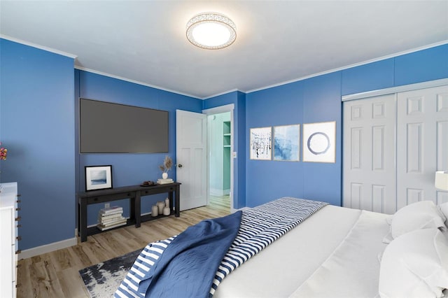 bedroom with ornamental molding, a closet, and light hardwood / wood-style floors