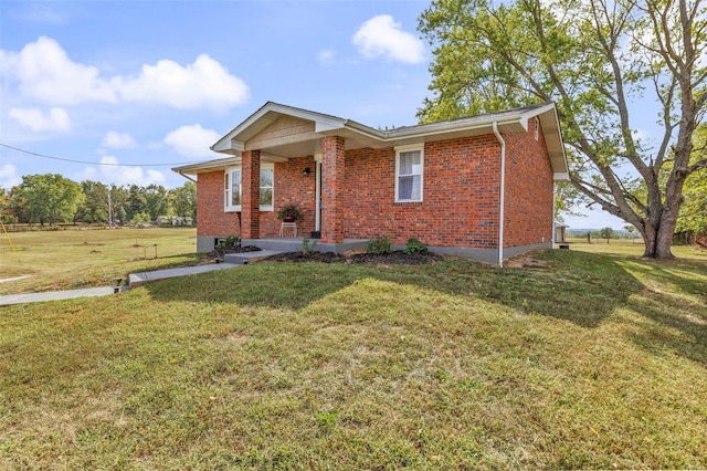 view of front facade featuring brick siding, a porch, and a front yard