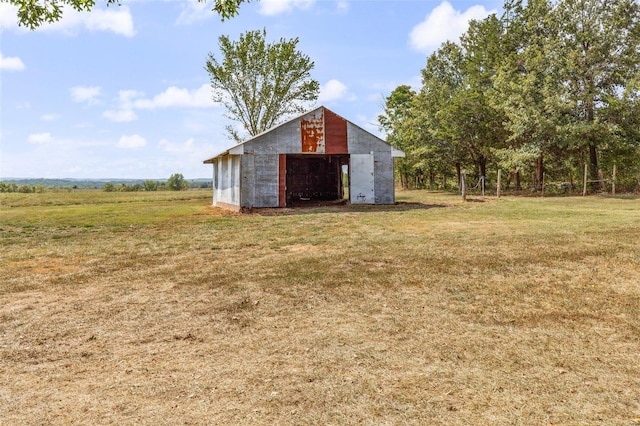 view of pole building featuring a rural view and a lawn