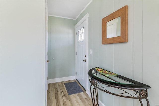 entrance foyer featuring ornamental molding, light wood-style flooring, and baseboards