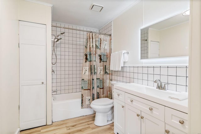 full bath featuring toilet, wood finished floors, vanity, tile walls, and shower / bath combination with curtain