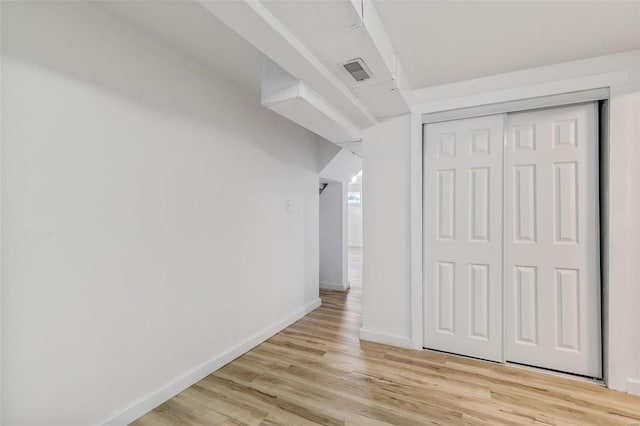 interior space featuring a closet, visible vents, light wood-style flooring, and baseboards