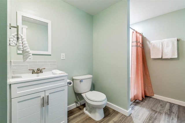 full bath with toilet, wood finished floors, vanity, baseboards, and a shower with curtain