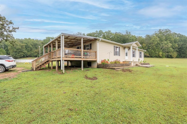 rear view of property featuring a yard and a wooden deck