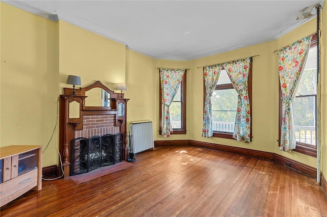 living room featuring radiator heating unit, hardwood / wood-style flooring, plenty of natural light, and crown molding