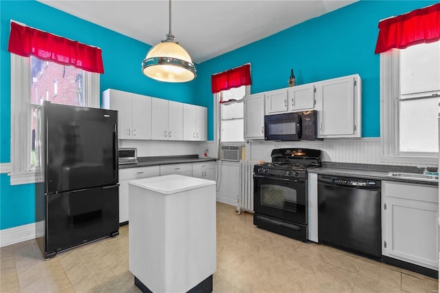 kitchen featuring black appliances, plenty of natural light, and white cabinets