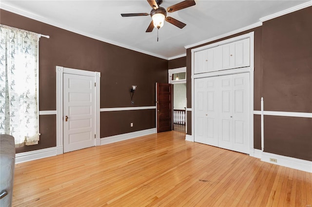 unfurnished bedroom featuring ceiling fan, a closet, light hardwood / wood-style floors, and ornamental molding