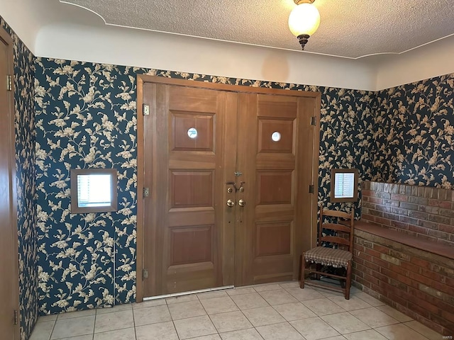 tiled entryway featuring a textured ceiling