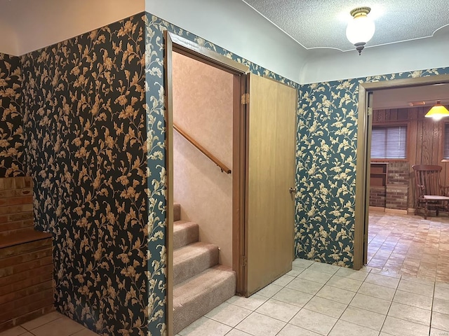 stairway featuring a textured ceiling and tile patterned flooring