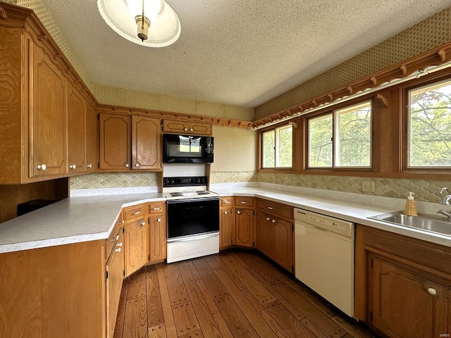 kitchen featuring white appliances, a textured ceiling, dark wood-type flooring, and sink