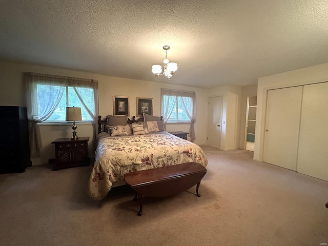 carpeted bedroom featuring a notable chandelier, a closet, and a textured ceiling