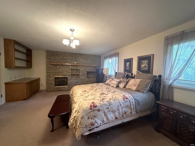 bedroom featuring a notable chandelier, a textured ceiling, carpet floors, and a fireplace