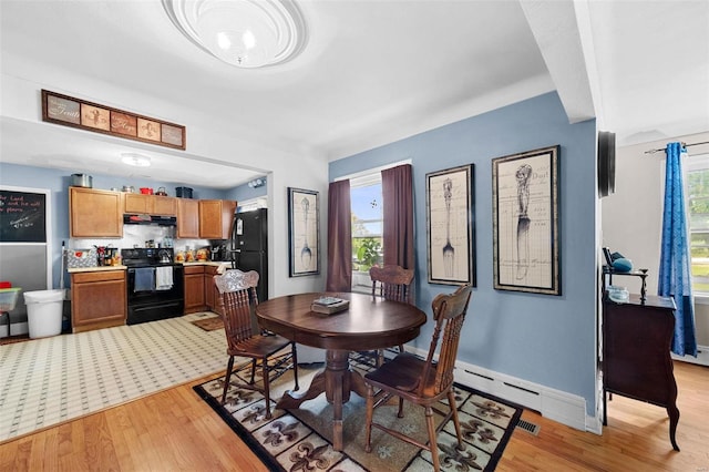 dining area with light hardwood / wood-style floors and baseboard heating