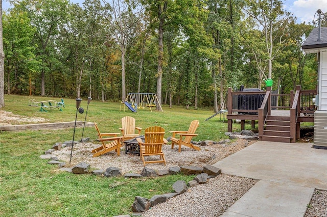 view of yard with a playground, a fire pit, a patio area, and central AC unit