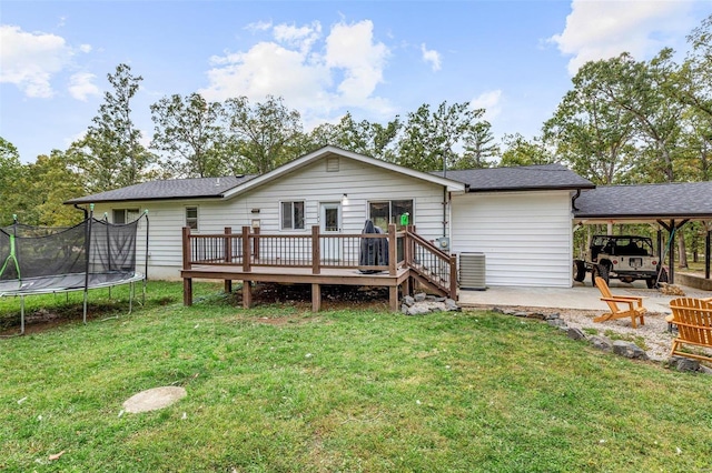 back of property with a trampoline, a deck, a yard, and a patio