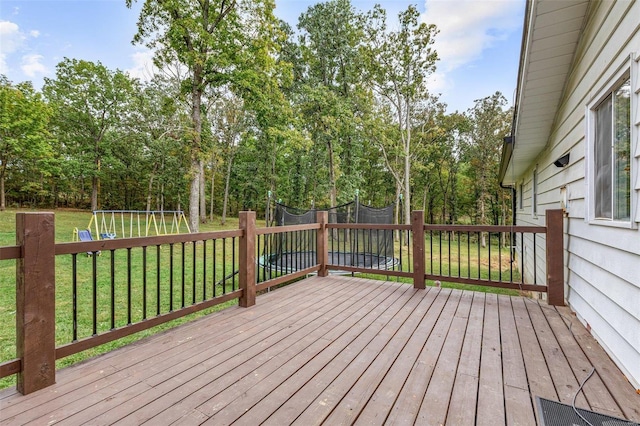 wooden terrace featuring a trampoline and a yard