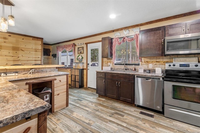 kitchen featuring light hardwood / wood-style flooring, dark brown cabinets, appliances with stainless steel finishes, and sink