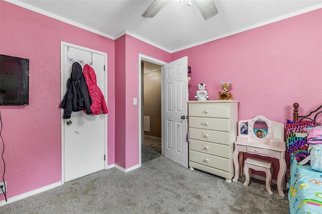 carpeted bedroom with a textured ceiling, crown molding, ceiling fan, and a closet