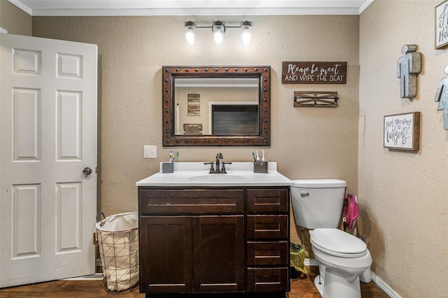 bathroom featuring ornamental molding, vanity, toilet, and wood-type flooring