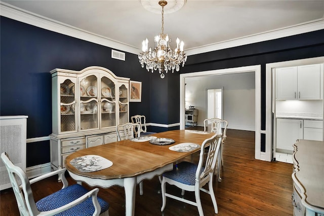 dining area featuring ornamental molding, dark wood-type flooring, and an inviting chandelier