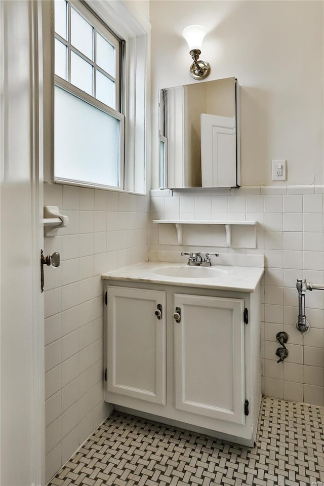 bathroom featuring vanity and tile walls