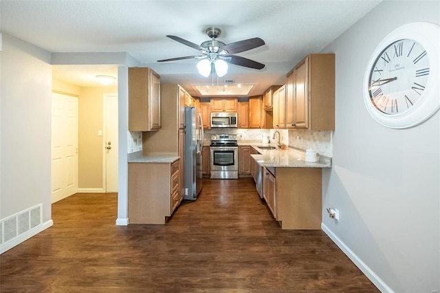 kitchen with sink, dark hardwood / wood-style floors, decorative backsplash, light stone countertops, and appliances with stainless steel finishes