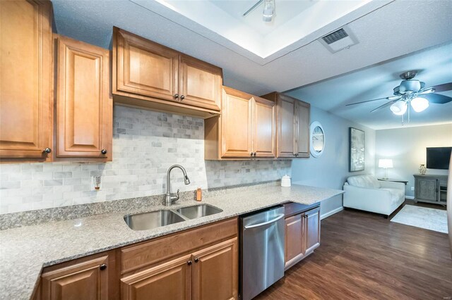 kitchen with light stone countertops, decorative backsplash, dark hardwood / wood-style flooring, stainless steel dishwasher, and sink