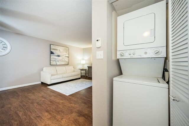 laundry room featuring stacked washing maching and dryer and dark hardwood / wood-style floors